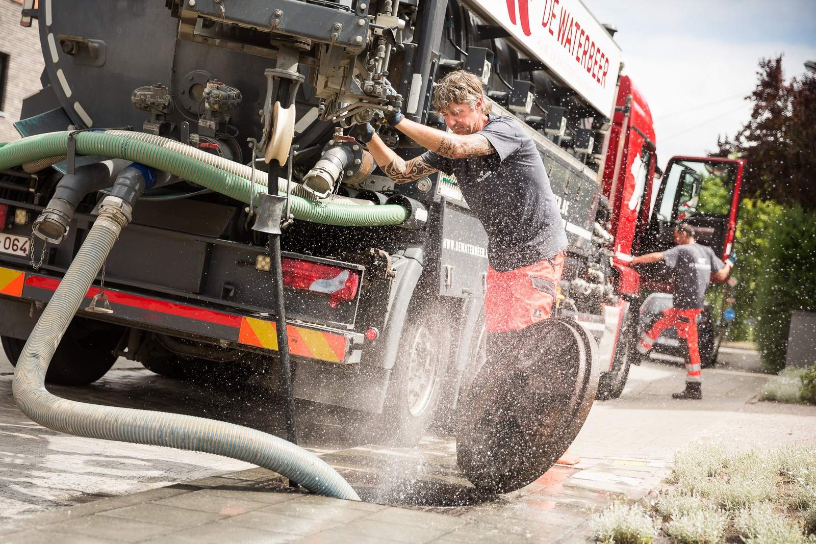 Ruimwagen en slang bij het reinigen van een put