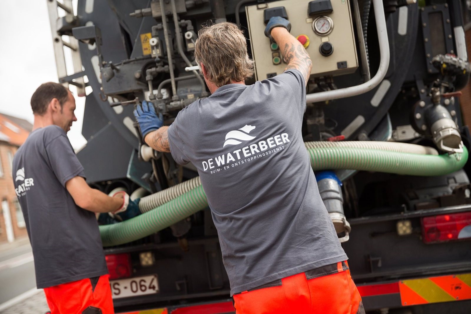 Vakman met ruimslang aan een ruimwagen